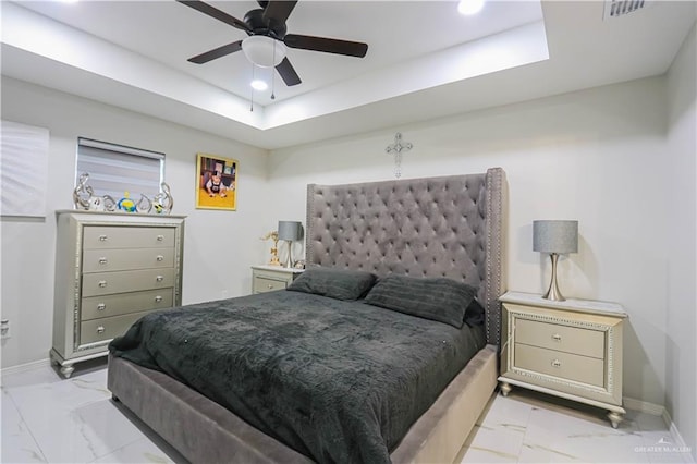 bedroom featuring a raised ceiling and ceiling fan