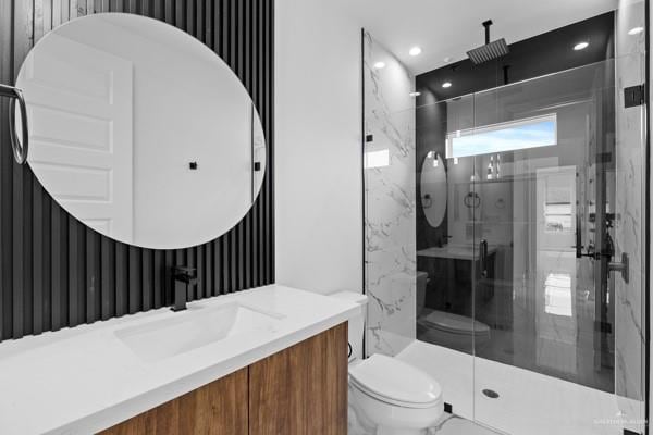 bathroom with toilet, vanity, and a shower with shower door