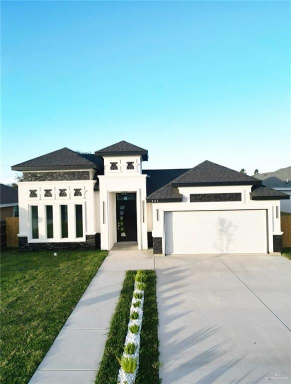 prairie-style home featuring a garage and a front lawn