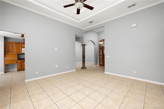 empty room with crown molding, light tile patterned floors, ceiling fan, and a tray ceiling