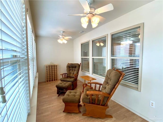 sitting room with light hardwood / wood-style floors and ceiling fan