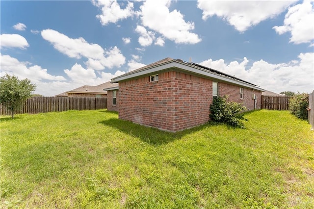 view of side of home with a yard