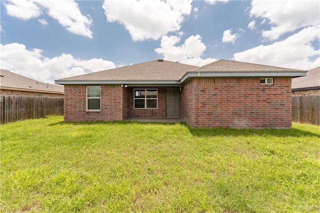 rear view of house featuring a lawn