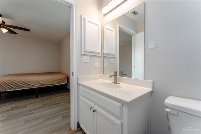 bathroom with ceiling fan, toilet, vanity, and hardwood / wood-style flooring