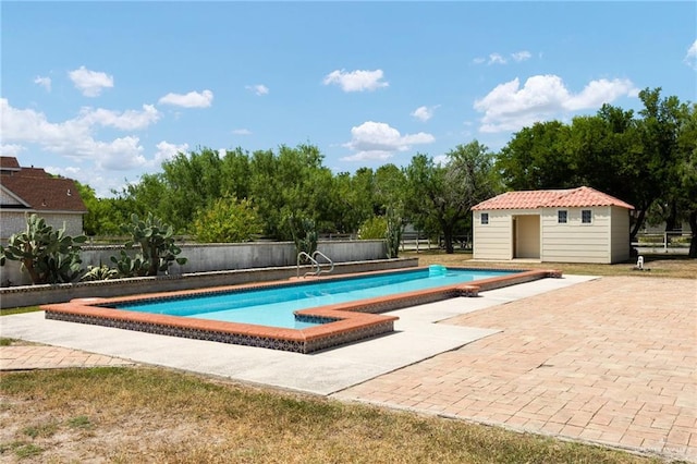 view of swimming pool with a patio area and an outdoor structure