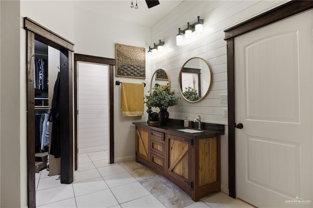 bathroom with vanity, tile patterned floors, ceiling fan, and wood walls