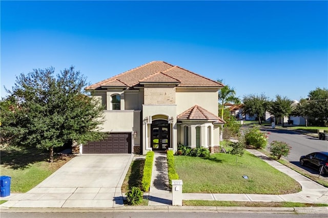 mediterranean / spanish house featuring french doors, a garage, and a front yard