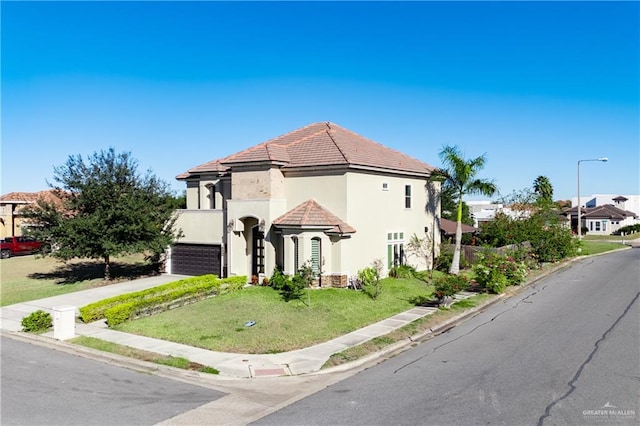 mediterranean / spanish house with a garage and a front yard