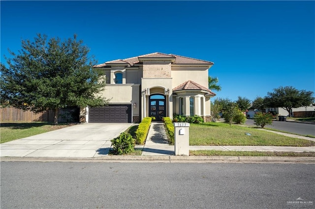 mediterranean / spanish-style home with a garage and a front yard