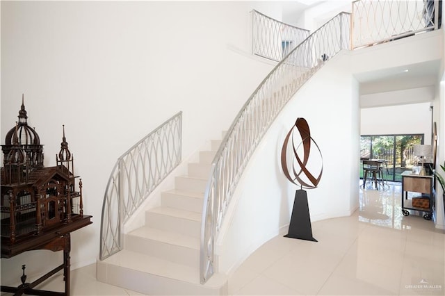 stairs with a high ceiling and tile patterned flooring