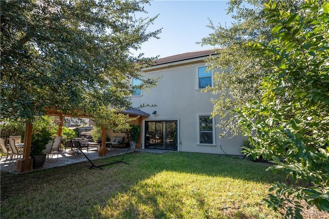 rear view of house featuring a patio and a yard