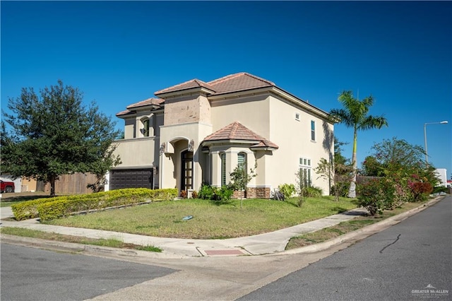 mediterranean / spanish home with a garage and a front lawn