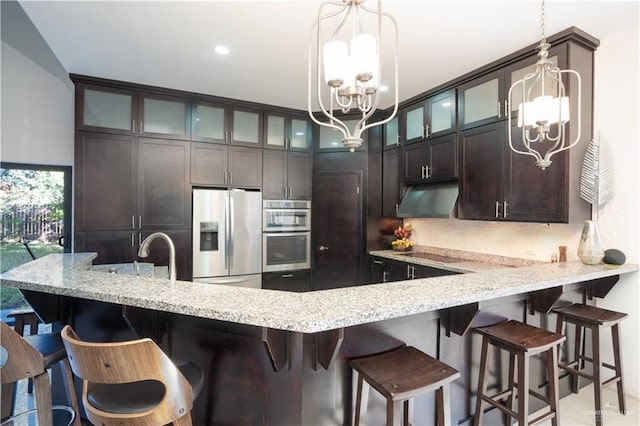 kitchen with dark brown cabinetry, a chandelier, hanging light fixtures, kitchen peninsula, and stainless steel appliances