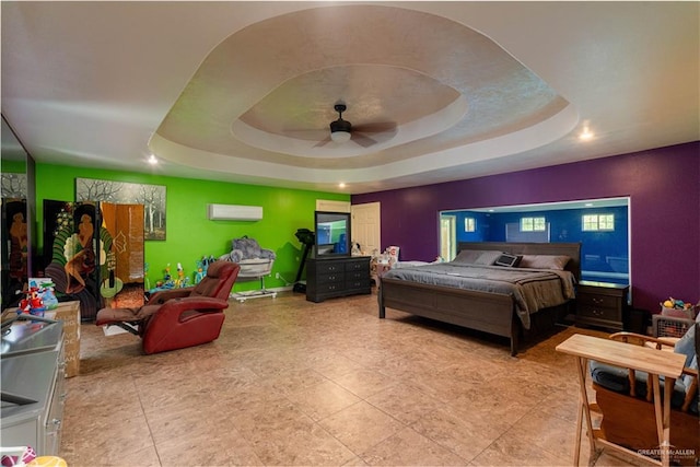 bedroom featuring a wall mounted air conditioner, a tray ceiling, and ceiling fan