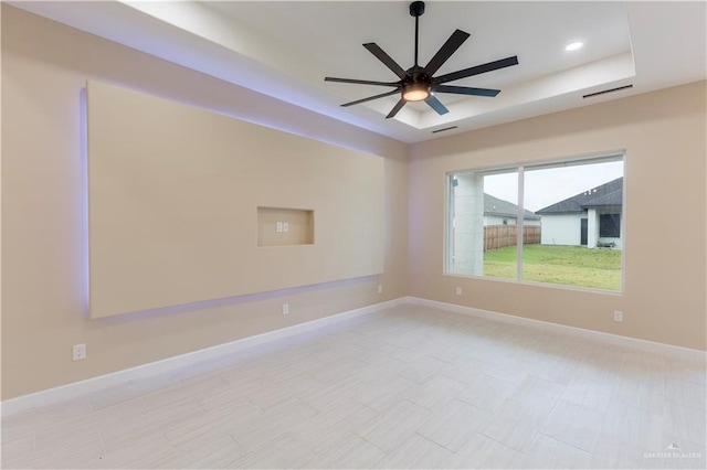 unfurnished room featuring a tray ceiling and ceiling fan