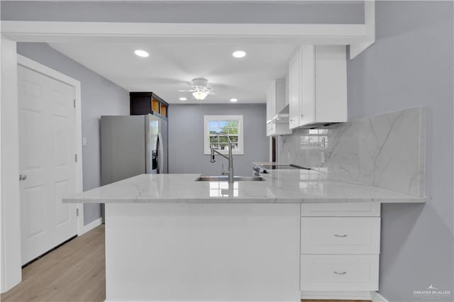 517 E Jones Ave, Pharr, TX 78577 - kitchen featuring white cabinetry, a peninsula, recessed lighting, light stone countertops, and stainless steel fridge with ice dispenser