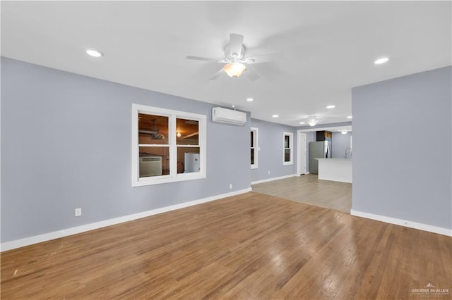 517 E Jones Ave, Pharr, TX 78577 - unfurnished living room with a wall mounted AC, a ceiling fan, wood finished floors, and recessed lighting