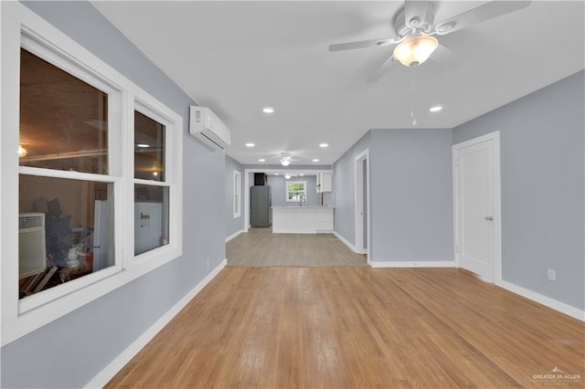 517 E Jones Ave, Pharr, TX 78577 - unfurnished living room with an AC wall unit, light wood-type flooring, ceiling fan, and recessed lighting