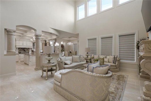 living room with ornate columns, coffered ceiling, beamed ceiling, a notable chandelier, and a towering ceiling