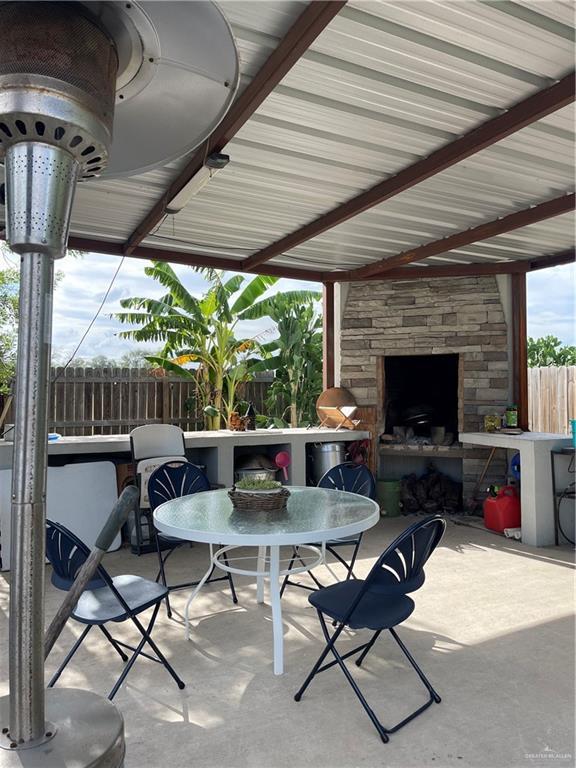 2205 Griffin Pass, Edinburg, TX 78542 - view of patio featuring an outdoor stone fireplace and fence