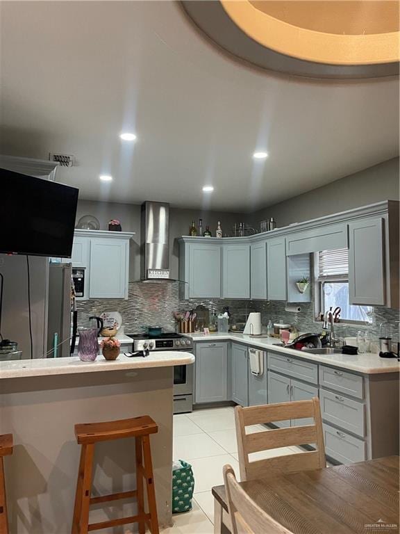 2205 Griffin Pass, Edinburg, TX 78542 - kitchen featuring wall chimney exhaust hood, appliances with stainless steel finishes, decorative backsplash, light countertops, and a breakfast bar