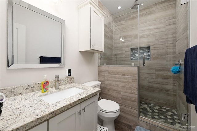 full bath with toilet, a stall shower, recessed lighting, and vanity