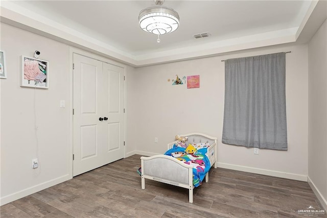 living area with baseboards, visible vents, and wood finished floors