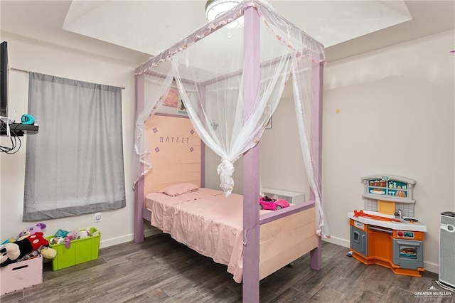 bedroom with dark wood finished floors and baseboards