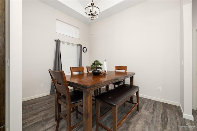 dining room featuring dark wood-style floors, baseboards, and a notable chandelier