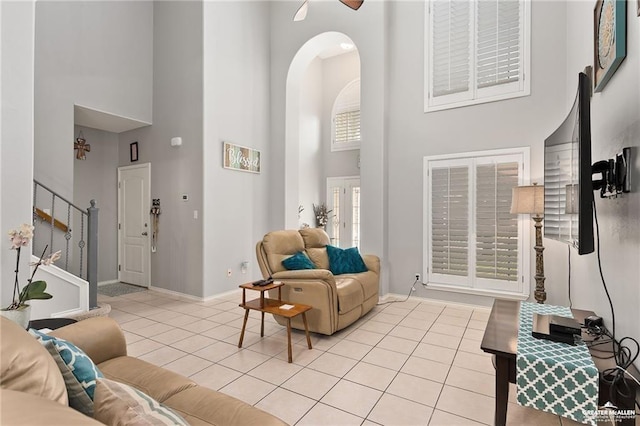 living room with light tile patterned floors and a high ceiling