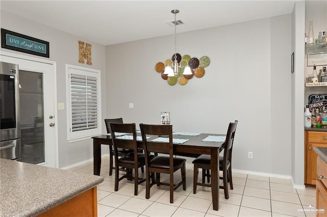 tiled dining area with an inviting chandelier