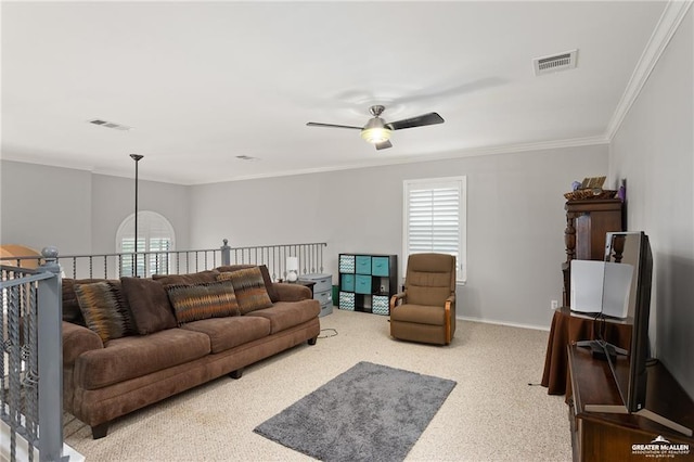 living room featuring a healthy amount of sunlight, light colored carpet, ceiling fan, and crown molding