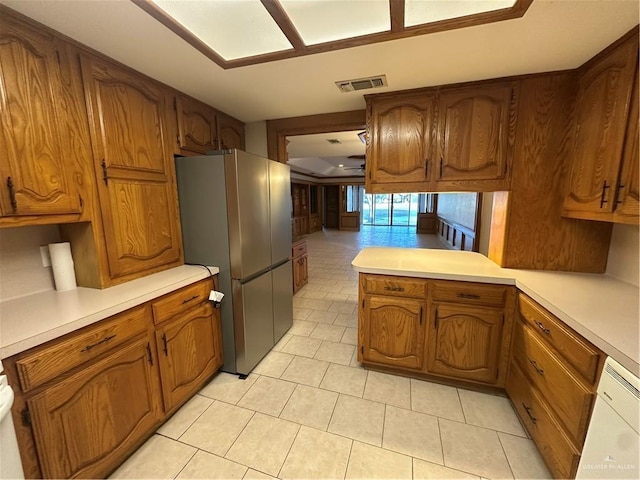 2711 Ashley Ct, Pharr, TX 78577 - kitchen featuring brown cabinetry, visible vents, light countertops, and freestanding refrigerator