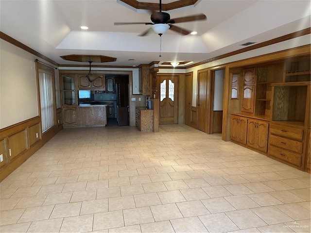 2711 Ashley Ct, Pharr, TX 78577 - unfurnished living room featuring a wainscoted wall, a raised ceiling, visible vents, ornamental molding, and a ceiling fan
