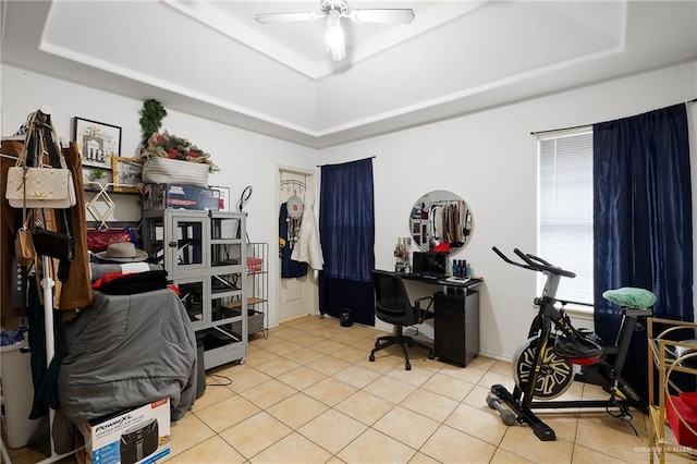 office area featuring ceiling fan, a raised ceiling, and light tile patterned flooring