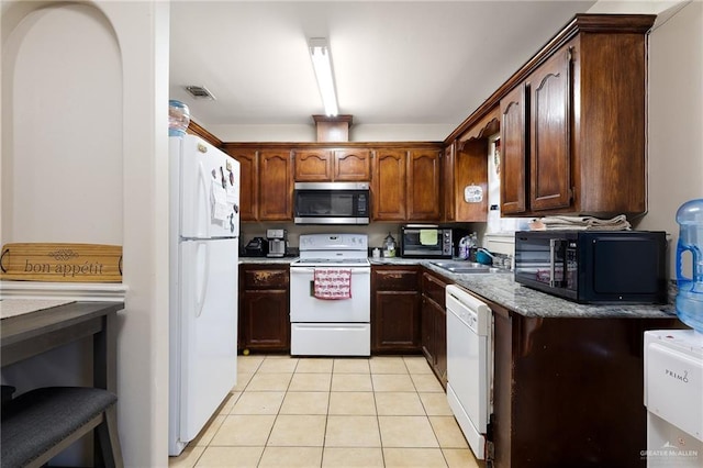 kitchen with white appliances, visible vents, a sink, and light tile patterned floors