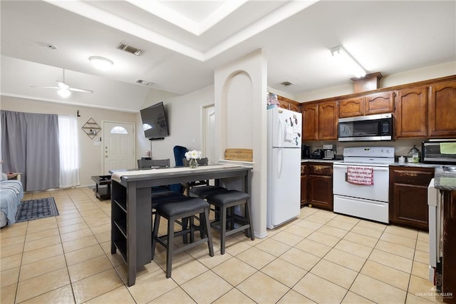 kitchen featuring light tile patterned floors, white appliances, open floor plan, and visible vents