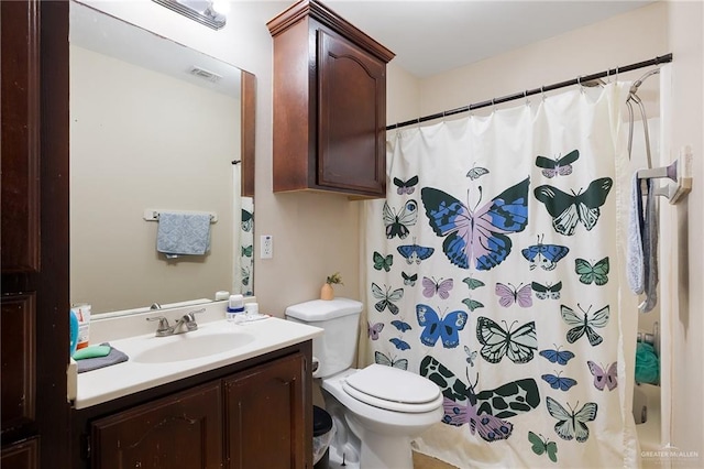 bathroom featuring toilet, a shower with shower curtain, and vanity