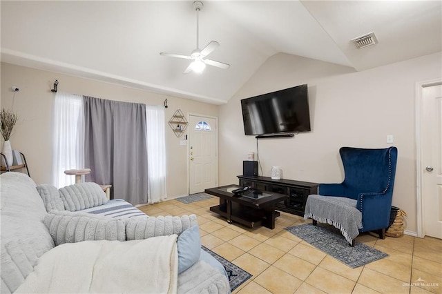 living room featuring lofted ceiling, light tile patterned flooring, visible vents, and a ceiling fan