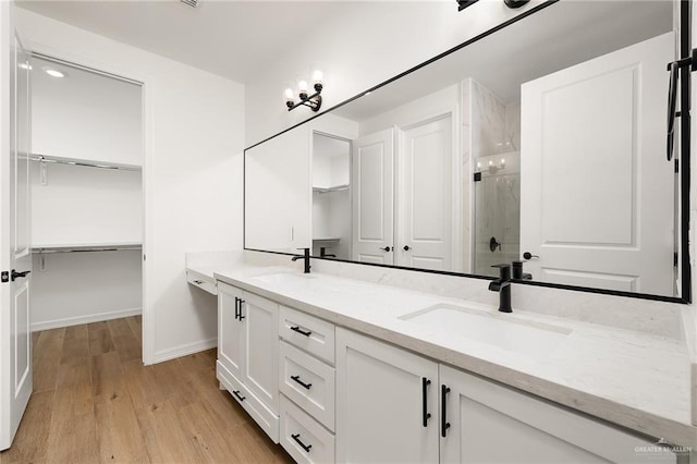 3515 Elevation Dr, Edinburg, TX 78542 - bathroom with a sink, a stall shower, baseboards, wood finished floors, and a walk in closet