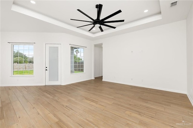 3515 Elevation Dr, Edinburg, TX 78542 - unfurnished room featuring light wood-type flooring, visible vents, a raised ceiling, and a healthy amount of sunlight