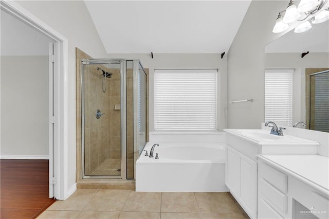 bathroom with tile patterned floors, vanity, plus walk in shower, and vaulted ceiling