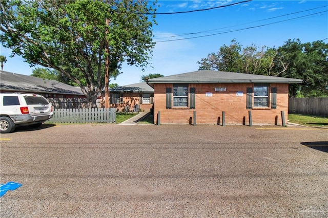 bungalow-style house with brick siding and fence