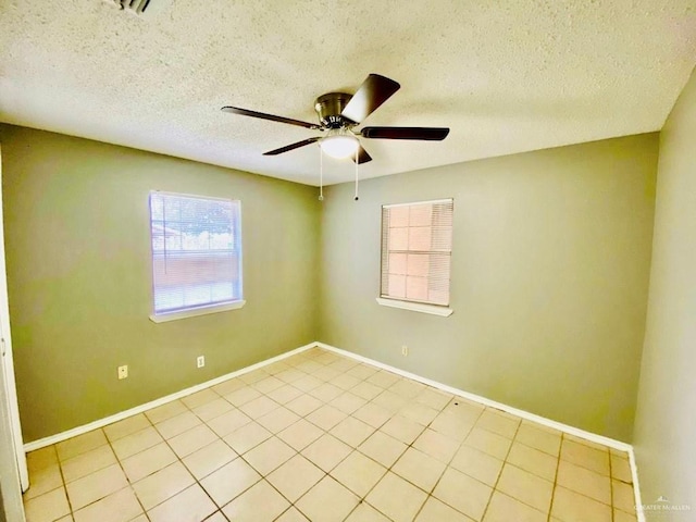 unfurnished room featuring baseboards, a textured ceiling, ceiling fan, and light tile patterned flooring