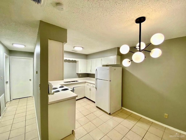 kitchen featuring white cabinets, light countertops, a textured ceiling, freestanding refrigerator, and pendant lighting