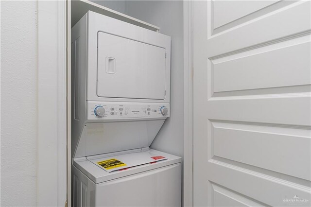 clothes washing area with stacked washer / dryer