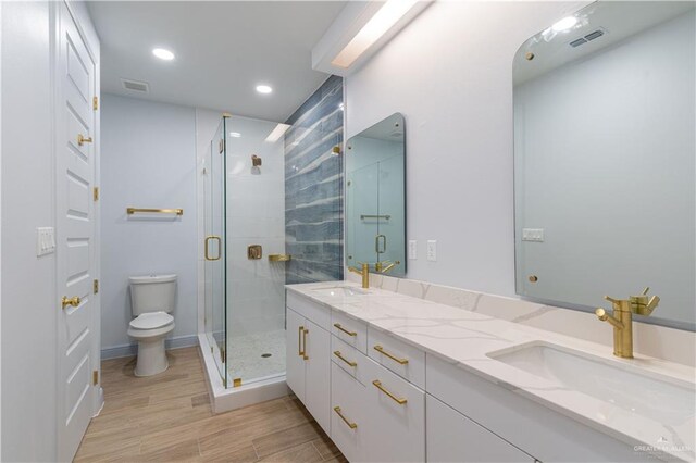 bathroom featuring hardwood / wood-style floors, vanity, toilet, and walk in shower