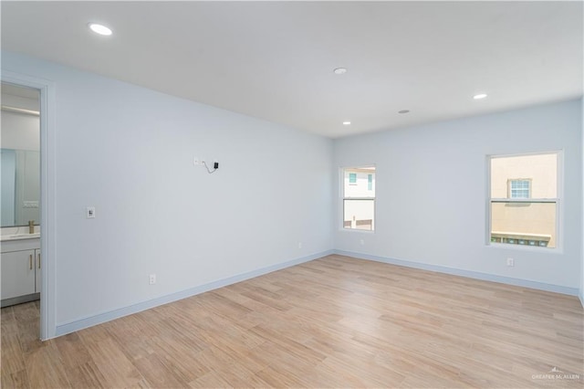 empty room with light hardwood / wood-style flooring and sink