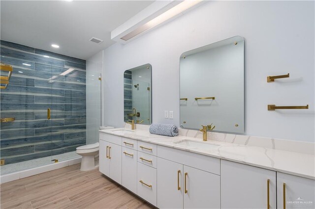 bathroom with vanity, hardwood / wood-style flooring, toilet, and a shower with shower door