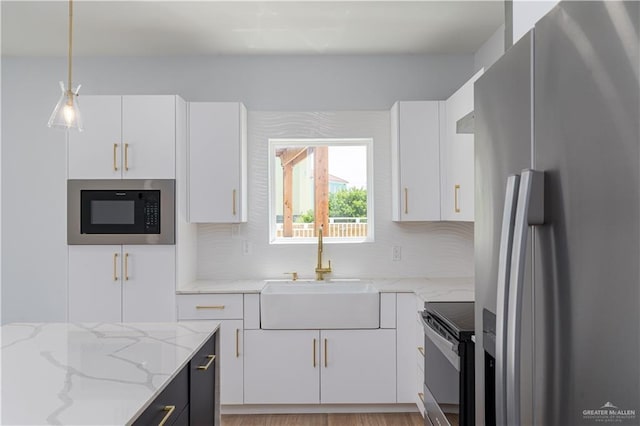 kitchen with sink, white cabinets, and appliances with stainless steel finishes